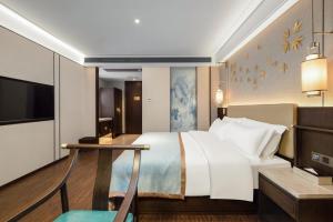 长沙廷泊酒店长沙洋湖中医药大学店的酒店客房设有一张大床和一张桌子。