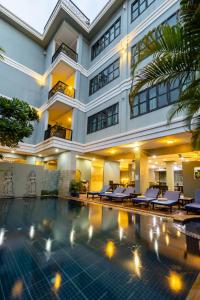 暹粒Siem Reap Comforts Hostel的大楼前设有游泳池的酒店