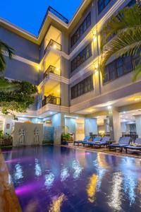 暹粒Siem Reap Comforts Hostel的大楼前的酒店游泳池