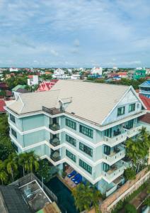 暹粒Siem Reap Comforts Hostel的享有棕榈树白色建筑的顶部景色