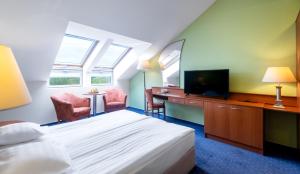 采格莱德阿夸莱尔酒店的酒店客房设有一张床、一张书桌和一台电视机。