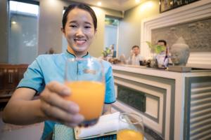暹粒Siem Reap Comforts Hostel的拿着一杯橙汁的女人