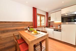 希洛谢克瓦利赛运动酒店的厨房铺有木地板,配有木桌。