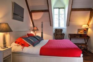 孔卡尔诺科利奥乐小庄园住宿加早餐旅馆的一间卧室配有一张带红色毯子的床