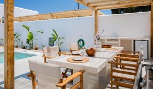 纳克索乔拉Petradia Villas的一间带桌椅的用餐室和一个游泳池