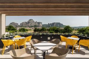 卡兰巴卡Mirabilis Boutique Hotel by Panel Hospitality的庭院配有桌椅,背景为山脉