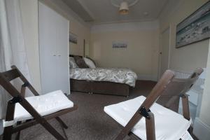 滨海绍森德SILVERDALE HOUSE的一间卧室配有两把椅子和一张床