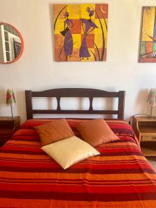 里奥马里纳Studio Rio Marina sul mare AC的一间卧室配有一张带红色和橙色毯子的床
