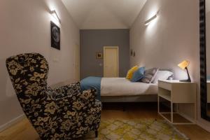 都灵Massena Modern Apartment by Wonderful Italy的一间卧室配有一张床、一把椅子和一把椅子