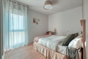 尚特皮OVELIA Rennes Chantepie - Le Patio Margot的一间卧室设有一张床和一个大窗户