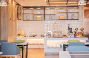 无锡莫林酒店无锡江南大学融创文旅城店的厨房里设有桌椅的餐厅