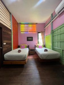 大城tamarind guesthouse的色彩鲜艳的客房内的两张床