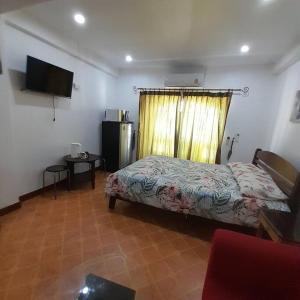 芭堤雅市中心Niran Grand Ville A4F的一间卧室设有一张床、一个窗口和一台电视