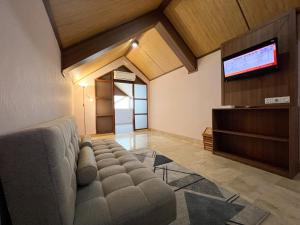 库塔伊斯坦纳拉玛大酒店的带沙发和平面电视的客厅