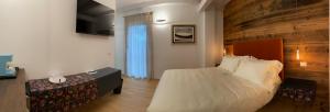 科尔蒙斯Cruna di Subida Wine Country House的一间卧室设有一张大床和木墙