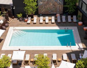 马德里Wellington Hotel & Spa Madrid的享有带躺椅的游泳池的顶部景致