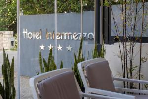 帕格Boutique Hotel Intermezzo - Pag centre的酒店入口前的一组椅子