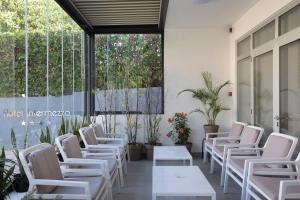 帕格Boutique Hotel Intermezzo - Pag centre的一间设有白色椅子和桌子及窗户的房间