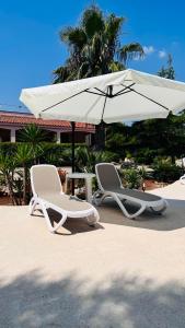 托雷桑塔萨宾娜I Giardini Dell'Agave的海滩上的两把椅子和一把遮阳伞