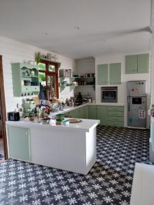 帕皮提Chalet Ohana, airport family house的厨房配有绿色橱柜和白色台面