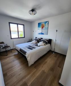 佩罗勒appartement 40 m 2的一间卧室设有一张大床,铺有木地板。