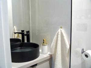 希隆斯克地区佩卡雷ZB Apartment BEIGE Piekary Śląskie的浴室设有黑色水槽和镜子