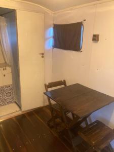 皮雷诺波利斯Salamandra trailerhome的一间设有桌子的房间和一扇带窗户的门