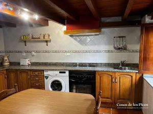RuenesVivienda vacacional El Cau - Casas de Los Picos的厨房配有洗衣机和水槽