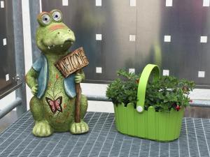 鲁斯特杜斯特旅馆的一只青蛙雕像坐在两株植物旁边的桌子上