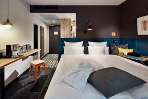 美因茨me and all hotel Mainz, part of JdV by Hyatt的一间卧室配有一张白色大床和蓝色床头板
