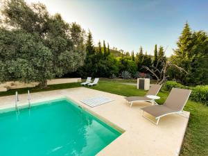 恩纳La Casa del Poeta Enna - Pergusa的庭院旁带两把椅子的游泳池