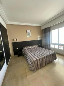 比塞大Andalucia Bizerte plage et piscine的一间卧室设有一张床和一个大窗户