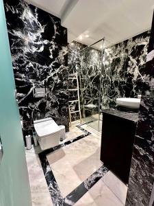 马拉喀什Majorelle Splendide Appartement的黑白浴室设有卫生间和水槽