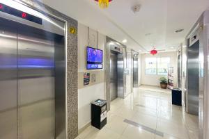 雅加达RedLiving Apartemen Bassura City - Ens Room的医院的走廊,设有电梯和电视
