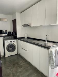 班拉克海滩Spacious Apartment by the Sea的厨房配有水槽和洗衣机