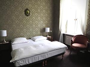 什切青Matejki 8的一间卧室设有两张床、一把椅子和一个窗户。