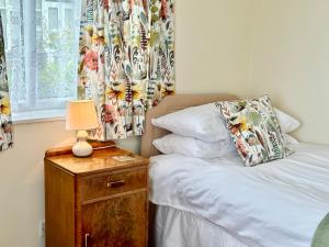 约克The Cottage的一间卧室配有一张床和一张带台灯的桌子