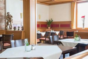 梅肯博伊伦Hotel Jägerhaus的一间带桌椅和雕像的用餐室