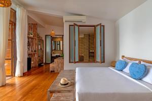库德岛库德岛温迪泳池度假酒店的卧室配有一张白色的大床和一张桌子