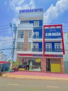 邦美蜀Kim Ngân Hotel Buôn Ma Thuột的蓝白色的建筑,带有金色的旅馆