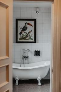 胡斯克瓦纳Hotel Slottsvillan的带浴缸的浴室和鸟的照片