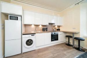 阿伯丁Rosemount Residence - SJA Stays的厨房配有白色橱柜、洗衣机和烘干机