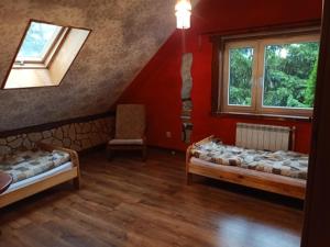 ZalesieNoclegi u Janusza的客房设有两张床和窗户。