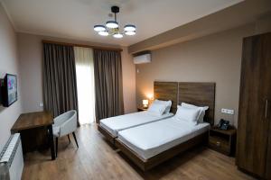 库塔伊西Gelati Residence的配有一张床和一张书桌的酒店客房