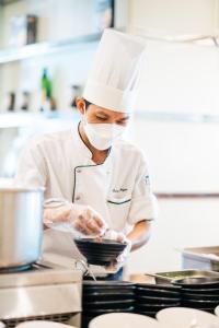 芽庄Sheraton Nha Trang Hotel & Spa的厨师在厨房准备食物