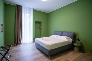 巴里Palazzo Zippitelli Apartments的绿色卧室设有床和窗户