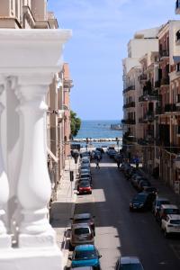 巴里Palazzo Zippitelli Apartments的享有街道和海洋的景致,街道上设有可停放的汽车。