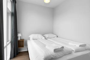 雷克雅未克Central Studio Apartment的白色的床,配有白色的床单和毛巾