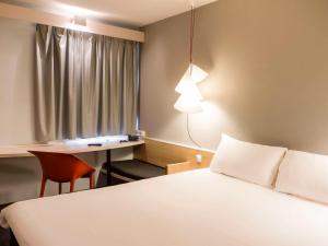 埃武拉埃武拉宜必思酒店的配有一张床、一张书桌和一扇窗户的酒店客房