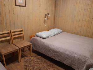 AinjaKäbi Holiday Homes的一间小卧室,配有一张床和一把椅子